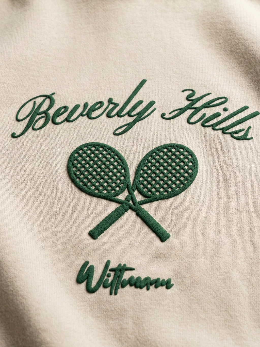 Beige hoodie with green 'Beverly Hills' and tennis racket design.