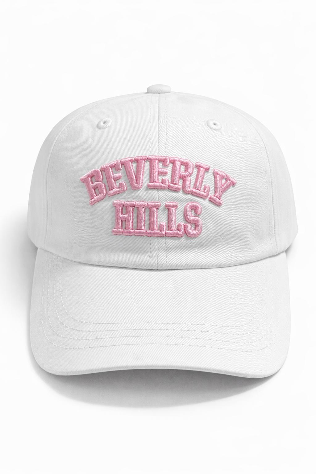 White cap with 'Beverly Hills' text in pink on a white background